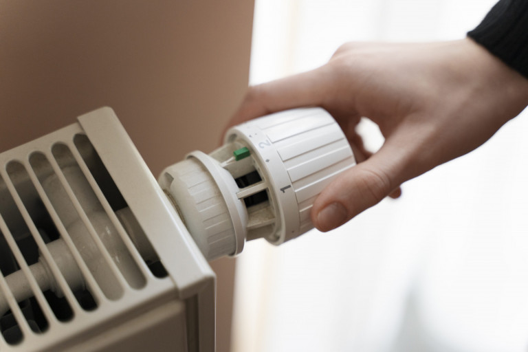 Фото: freepik.ru close-up-hand-turning-up-heater
